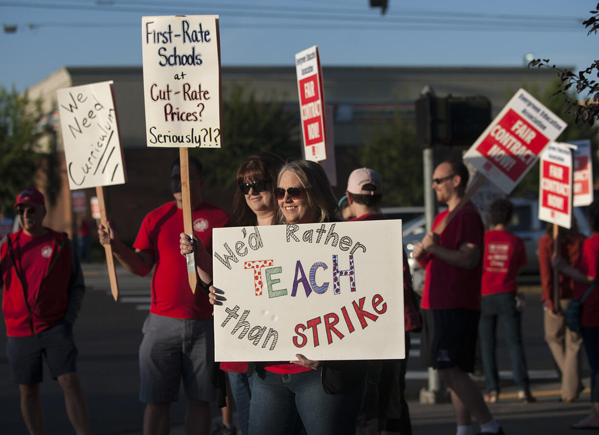 Teacher librarians Kristie Peak of Mill Plain Elementary School, foreground, and Beth Pfenning of Hearthwood Elementary School join picketers Friday morning, Aug. 19, 2016 in Southeast Vancouver.