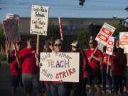 Teacher librarians Kristie Peak of Mill Plain Elementary School, foreground, and Beth Pfenning of Hearthwood Elementary School join picketers Friday morning, Aug. 19, 2016 in Southeast Vancouver.