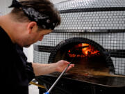 Joey Chmiko, owner and chef of Nonavo Pizza, adds wood to the oven at his newly opened pizzeria in downtown Vancouver on Wednesday. Despite a quiet opening, Nonavo is already selling out of lunch and dinner on occasion.