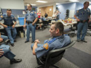 Trooper Jeff Wallace, center, chats with other members of the department as they gather for a barbecue Monday at Washington State Patrol District 5 Headquarters. Wallace is one of six troopers who transferred to the area this week, marking the first time in nearly four years the region has been fully staffed.