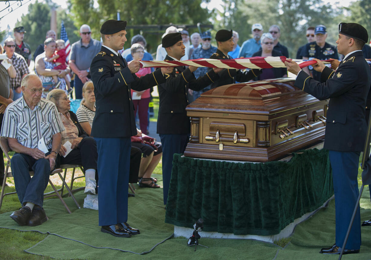 Members of Army Pfc. William Butz&#039;s family look on as an honor guard from Joint Base Lewis-McChord fold the flag that had covered the casket Friday morning at Evergreen Memorial Gardens.