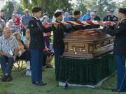 Members of Army Pfc. William Butz&#039;s family look on as an honor guard from Joint Base Lewis-McChord fold the flag that had covered the casket Friday morning at Evergreen Memorial Gardens.