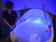 Marilyn Olmsted, co-owner of Urban Float Vancouver, a sensory deprivation tank spa, sits with a tank in a private room.