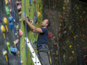 Hanz Kroesen, co-owner of Source Climbing Center, works on attaching holds.