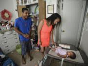 Nathan and Marina Brazille spend time with their 2-month-old daughter, Rose, at their apartment, which they secured with help from the Housing Relief Fund.