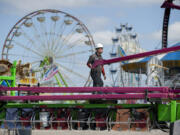 Gabriel Aguilar of Butler Amusements on Wednesday helps assemble the ride Vertigo as preparations continued for the Clark County Fair. The fair opens its 10-day run Friday. More information is at www.clarkcofair.com.