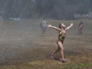 Madison Reaves, 6, of Washougal plays one of her favorite games, &quot;dancing in the rain,&quot; while beating the heat at Hamllik Park in Washougal on Thursday.