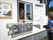 Ryan Thompson helps customer Peggy Dunn decide on a drink at Pines Coffee's kiosk at Mill Plain and Grand boulevards.