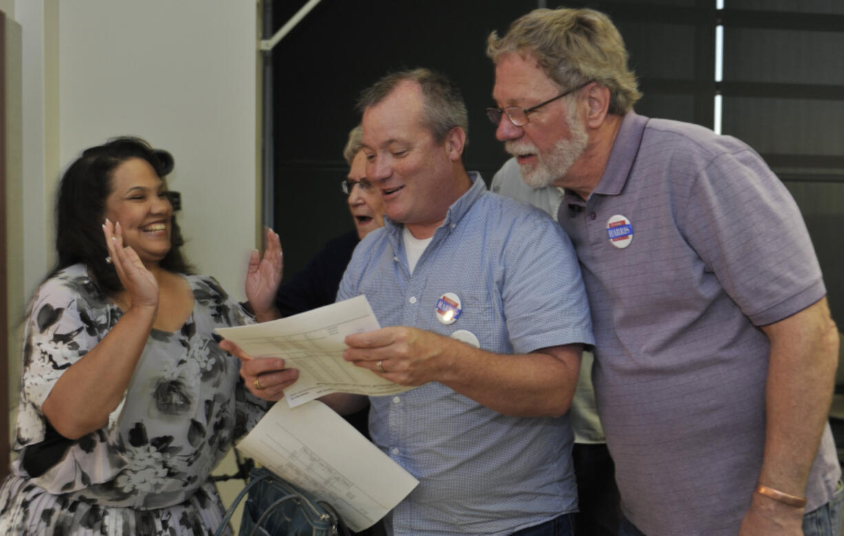 Council candidate Tanisha Harris, left, hears the election results from her campaign manager Steve Kuyatt, center,  with Pete Aller, right, at the Clark County Public Service building in Vancouver, Wa., Tuesday August 2, 2016.