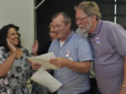 Council candidate Tanisha Harris, left, hears the election results from her campaign manager Steve Kuyatt, center,  with Pete Aller, right, at the Clark County Public Service building in Vancouver, Wa., Tuesday August 2, 2016.