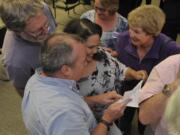 Council candidate Tanisha Harris, center, checks the election results as she is congratulated by her campaign manager Steve Kuyatt, bottom left, and her aunt Dian Stack and her mother Karen Harris, top center, at the Clark County Public Service building in Vancouver,  Tuesday.