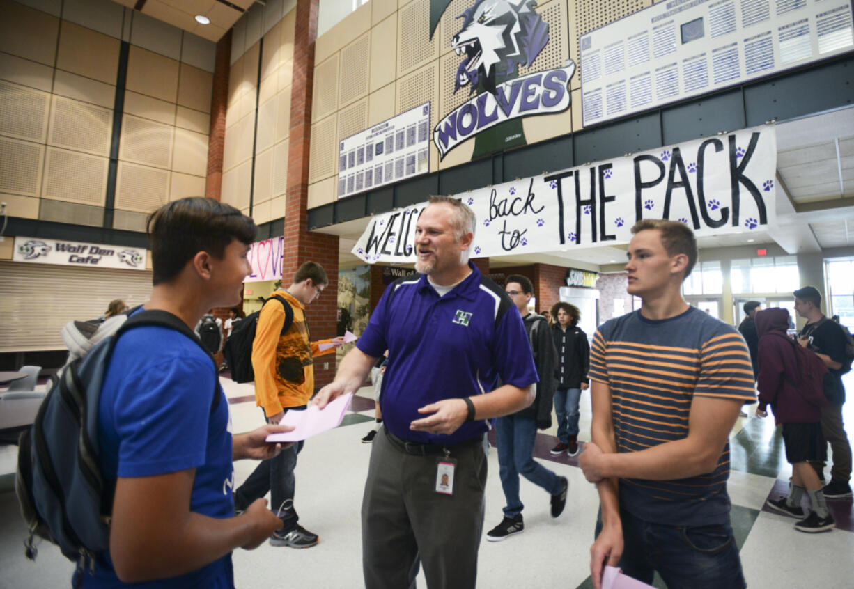 Heritage High School Principal Derek Garrison helps sophomores Anton Tikhonov, left, and Maksim Trukhlinskiy with their schedules Wednesday on the first day of class in Evergreen Public Schools.