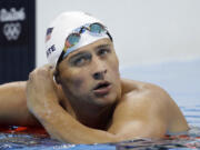 United States' Ryan Lochte checks his time in a men's 4x200-meter freestyle heat during the swimming competitions at the 2016 Summer Olympics, in Rio de Janeiro, Brazil. Lochte and three other American swimmers were robbed at gunpoint early Sunday, Aug. 14, by thieves posing as police officers who stopped their taxi and took their money and belongings, the U.S. Olympic Committee said.