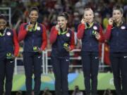 U.S. gymnasts, left to right, Simone Biles, Gabrielle Douglas, Lauren Hernandez, Madison Kocian and Aly Raisman hold their gold medals during the medal ceremony for the artistic gymnastics women's team at the 2016 Summer Olympics in Rio de Janeiro, Brazil, Tuesday, Aug. 9, 2016.