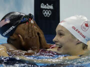 United States' Simone Manuel, left, and Canada's Penny Oleksiak celebrate winning joint gold and setting a new Olympic record in the women's 100-meter freestyle during the swimming competitions at the 2016 Summer Olympics, Thursday, Aug. 11, 2016, in Rio de Janeiro, Brazil.