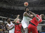 United States' DeAndre Jordan, center, scramble for a rebound with Serbia's Vladimir Stimac, right, during a men's basketball game at the 2016 Summer Olympics in Rio de Janeiro, Brazil, Friday, Aug. 12, 2016.