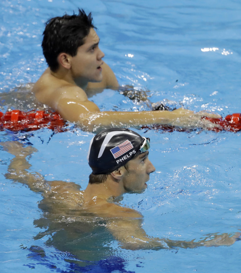 United States' Michael Phelps, bottom, and Singapore's Joseph Schooling look at the clock at the end of the men's 100-meter butterfly final during the swimming competitions at the 2016 Summer Olympics, Friday, Aug. 12, 2016, in Rio de Janeiro, Brazil.