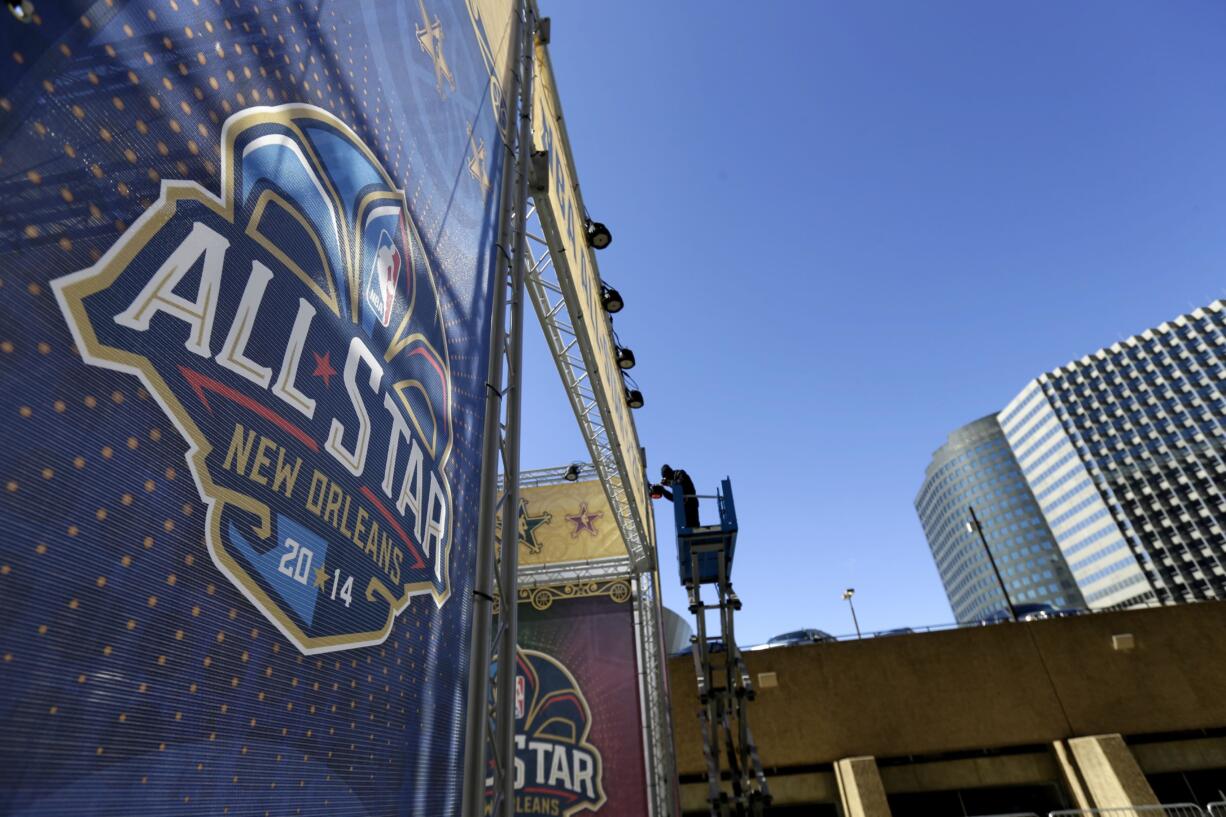 A worker attaches a banner to a scaffolding in New Orleans in preparation of the 2014 NBA All-Star basketball game. The NBA has decided to hold the 2017 All-Star Game in New Orleans, a person familiar with the decision told The Associated Press. The person spoke to the AP on condition of anonymity Friday, Aug. 19, 2016, because the decision hasn't been announced. New Orleans replaces Charlotte, which was set to host the game until the NBA decided last month that it wouldn't hold its marquee, mid-season event in North Carolina because of a state law that limits anti-discrimination protections for lesbian, gay and transgender people.