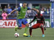 Seattle Sounders forward Clint Dempsey, left, moves the ball around Portland Timbers midfielder Diego Chara, right, in the first half of an MLS soccer match, Sunday, Aug. 21, 2016, in Seattle. (AP Photo/Ted S.