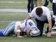 Dallas Cowboys quarterback Tony Romo is tended to by a trainer after he went down on a play against the Seattle Seahawks during the first half of a preseason NFL football game Thursday, Aug. 25, 2016, in Seattle.