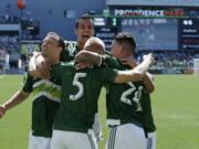 From left, Portland Timbers' Jack Jewsbury, Steven Taylor, Vytas Andriuskevicius (5), and Liam Ridgewell (24) celebrate after Andriuskevicius scored a goal against the Seattle Sounders in the first half of an MLS soccer match, Sunday, Aug. 28, 2016, in Portland, Ore. (AP Photo/Ted S.