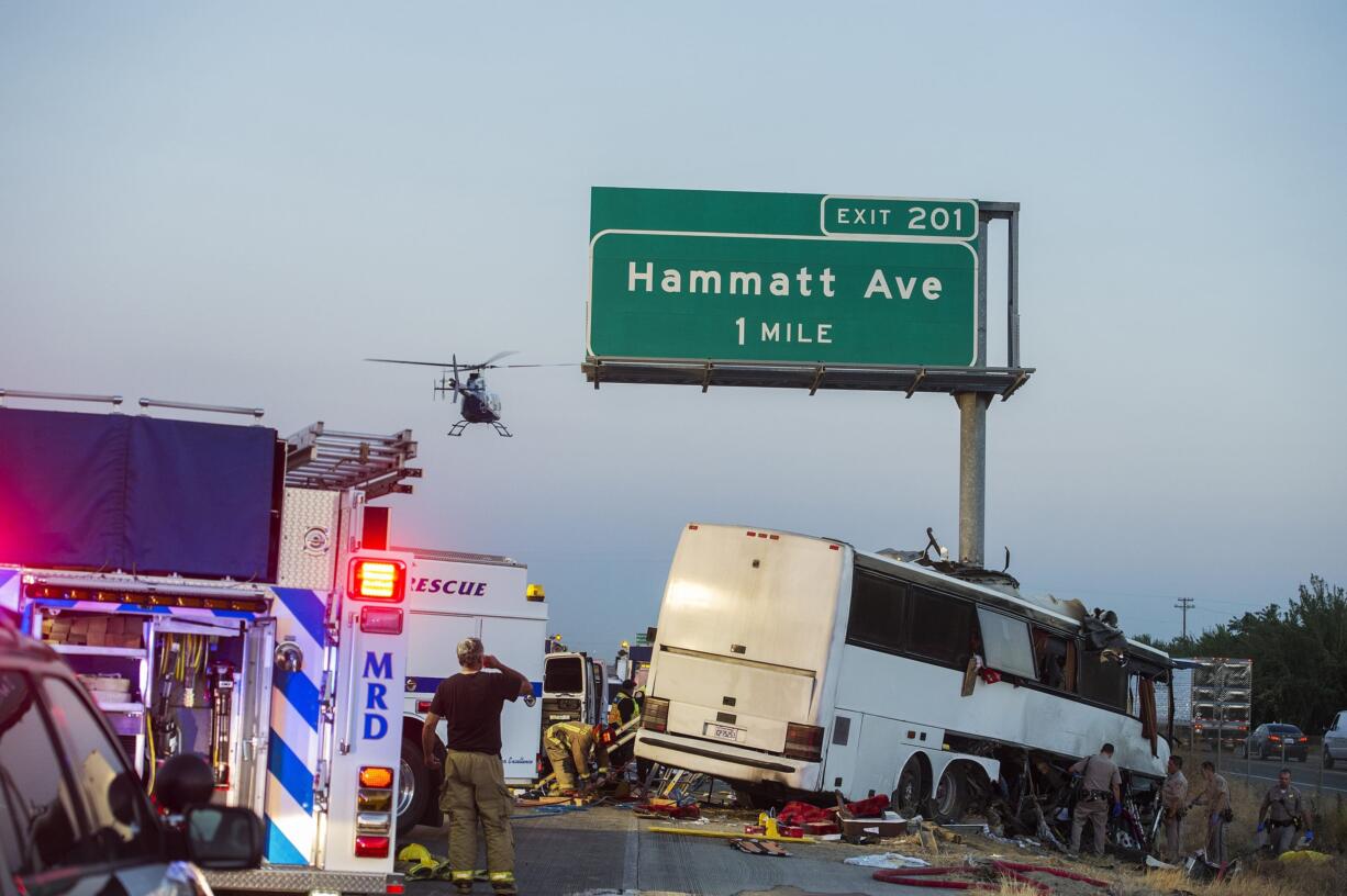 Rescue crews respond to the scene of a charter bus crash on northbound Highway 99 between Atwater and Livingston, Calif., Tuesday, Aug. 2, 2016. The bus veered off the central California freeway before dawn Tuesday and struck a pole that sliced the vehicle nearly in half, authorities said.