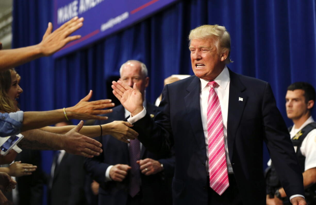 Republican presidential candidate Donald Trump greets the crowd as he arrives to speak at a campaign rally in Fredericksburg, Va., on Saturday.