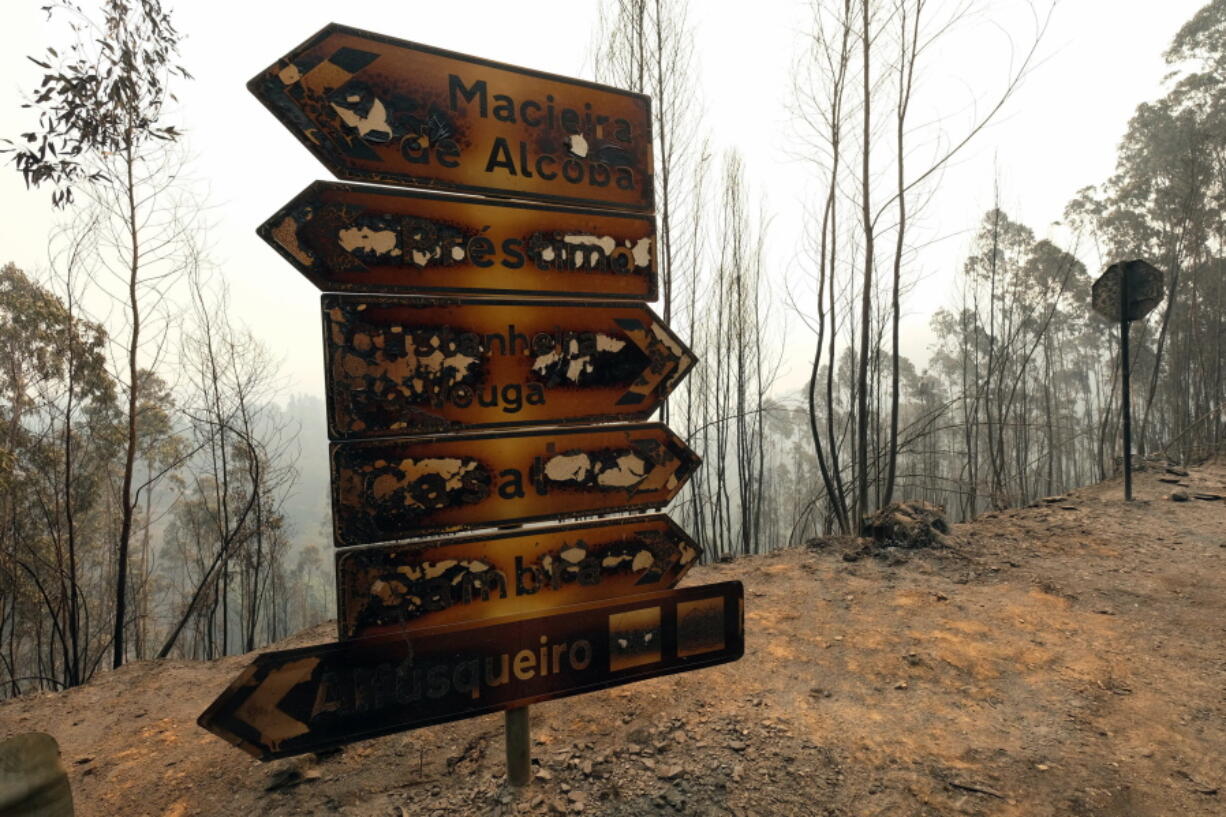 Burnt traffic signs stand by a road, Tuesday near Agueda, in the region of Aveiro, northern Portugal, where a fire raged Monday. The National Civil Protection Service said some 2,900 firefighters were in action Tuesday fighting dozens of forest fires. The worst-hit areas were in northern Portugal, where temperatures have exceeded 30 degrees Celsius (86 Fahrenheit) since Saturday.