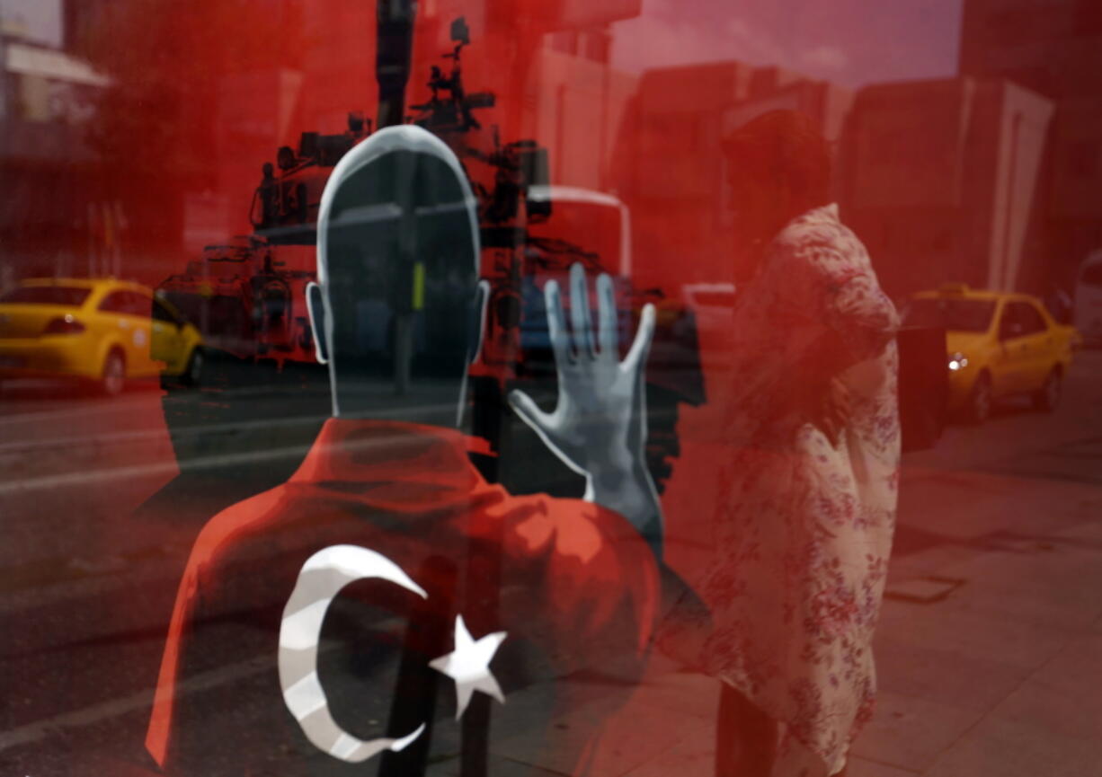 A woman is reflected in a poster made for an anti-coup rally Monday at Taksim Square in Istanbul. Turkey will continue fighting whatever powers seek to undermine the government, President Recep Tayyip Erdogan vowed Sunday as he addressed a rally.