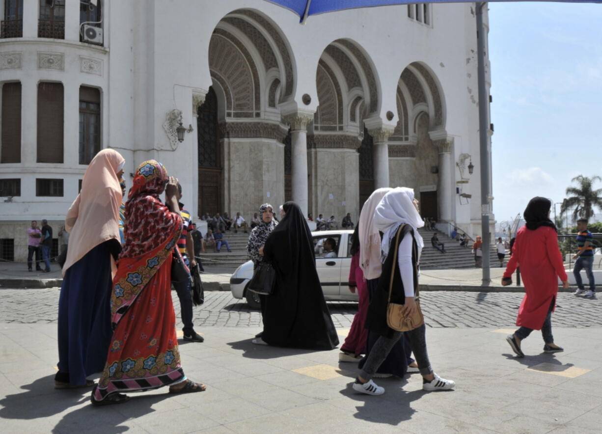 Veiled women walk Aug. 10 in central Algiers, Algeria.  A growing number of women in the country are wearing traditional Muslim attire.