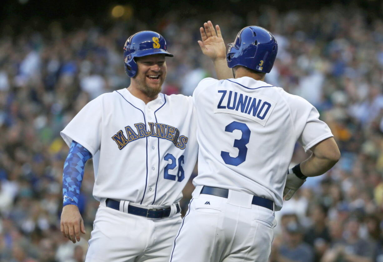 Seattle Mariners&#039; Mike Zunino (3) is greeted at the plate by Adam Lind, left, after Zunino hit a three-run home run to score Lind and Nelson Cruz during the first inning of a baseball game against the Los Angeles Angels, Friday, Aug. 5, 2016, in Seattle. (AP Photo/Ted S.