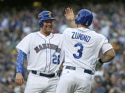 Seattle Mariners&#039; Mike Zunino (3) is greeted at the plate by Adam Lind, left, after Zunino hit a three-run home run to score Lind and Nelson Cruz during the first inning of a baseball game against the Los Angeles Angels, Friday, Aug. 5, 2016, in Seattle. (AP Photo/Ted S.