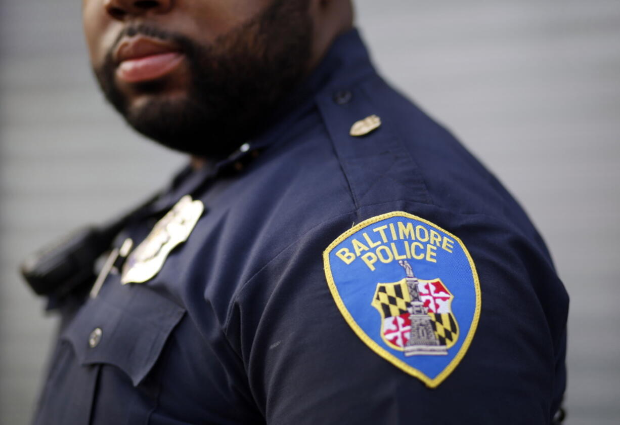 Baltimore Police Department Officer Jordan Distance stands on a street corner during a foot patrol in March. Baltimore officers routinely discriminate against blacks, according to a harshly critical Justice Department report presented Wednesday.