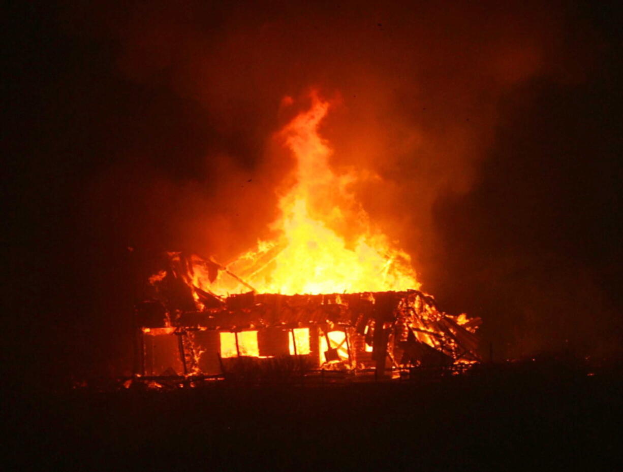 A structure along Highway 138 burns as a wildfire races through the Cajon Pass in San Bernardino county, Calif., on Tuesday. The wildfire that began as a small midmorning patch of flame next to Interstate 15 in the Cajon Pass had by Tuesday&#039;s end turned into a 28-square-mile monster that burned an untold number of homes.