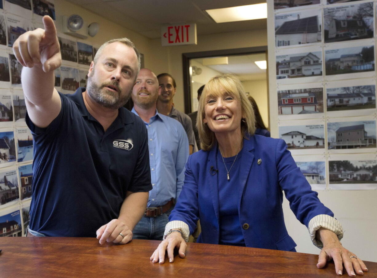 New Hampshire Gov. Maggie Hassan, right, smiles as Erik Shifflett shows off some of the success project his company, Granite State Solar, has done during a visit to the company Monday in Boscawen, N.H. Hassan is seeking the Democratic nomination for U.S. Senate and hopes to unseat U.S. Sen.