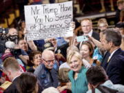 A man holds a sign that reads &quot;Mr. Trump Have You No Sense of Decency Sir&quot; as Democratic presidential candidate Hillary Clinton takes a photograph with a member of the audience after speaking at a rally at Abraham Lincoln High School, in Des Moines, Iowa, on Wednesday.