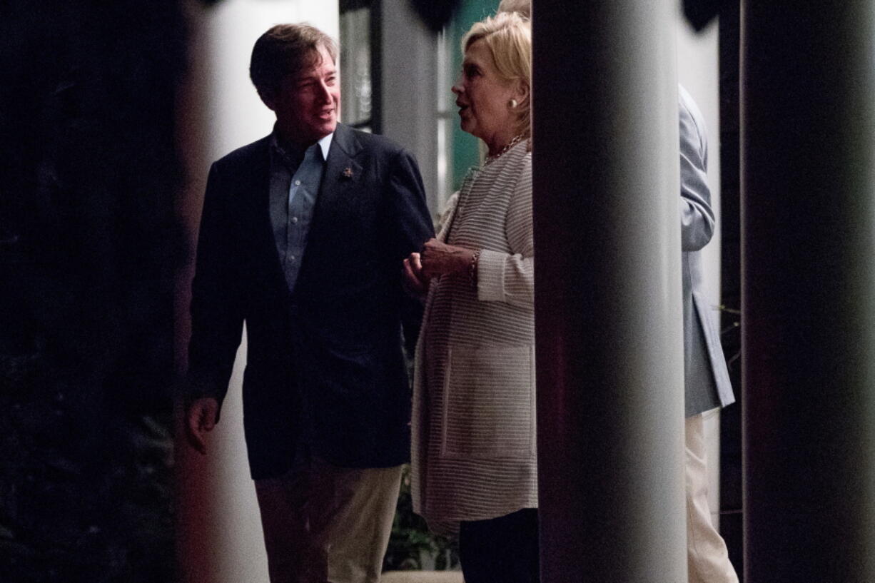 Democratic presidential candidate Hillary Clinton, right, accompanied by Democratic Party activist Jay Snyder, left, leaves after a fundraiser at his home in East Hampton, N.Y., on Monday.