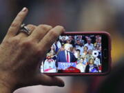 A person records as Republican presidential candidate Donald Trump speaks at a campaign rally in Akron, Ohio, on Monday.