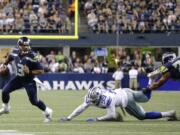 Seattle Seahawks quarterback Russell Wilson (3) scrambles away from Dallas Cowboys defensive end Ryan Russell (99) before throwing a touchdown pass to Tyler Lockett, not seen, duirng the second half of a preseason NFL football game, Thursday, Aug. 25, 2016, in Seattle.