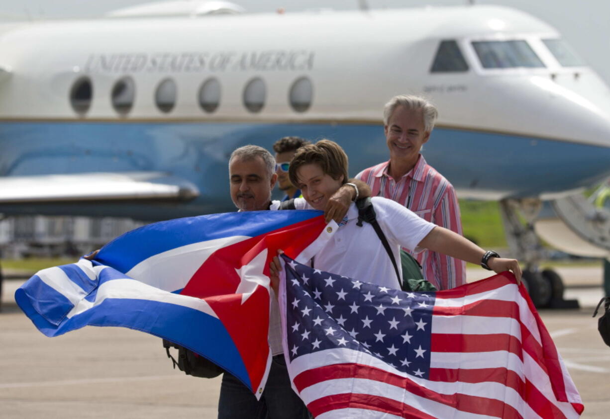 Passengers of JetBlue flight 387 holding a United States, and Cuban national flags, pose for photos in front of the plane transporting U.S. Transportation Secretary Anthony Foxx, at the airport in Santa Clara, Cuba, on Wednesda.