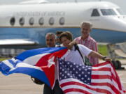 Passengers of JetBlue flight 387 holding a United States, and Cuban national flags, pose for photos in front of the plane transporting U.S. Transportation Secretary Anthony Foxx, at the airport in Santa Clara, Cuba, on Wednesda.