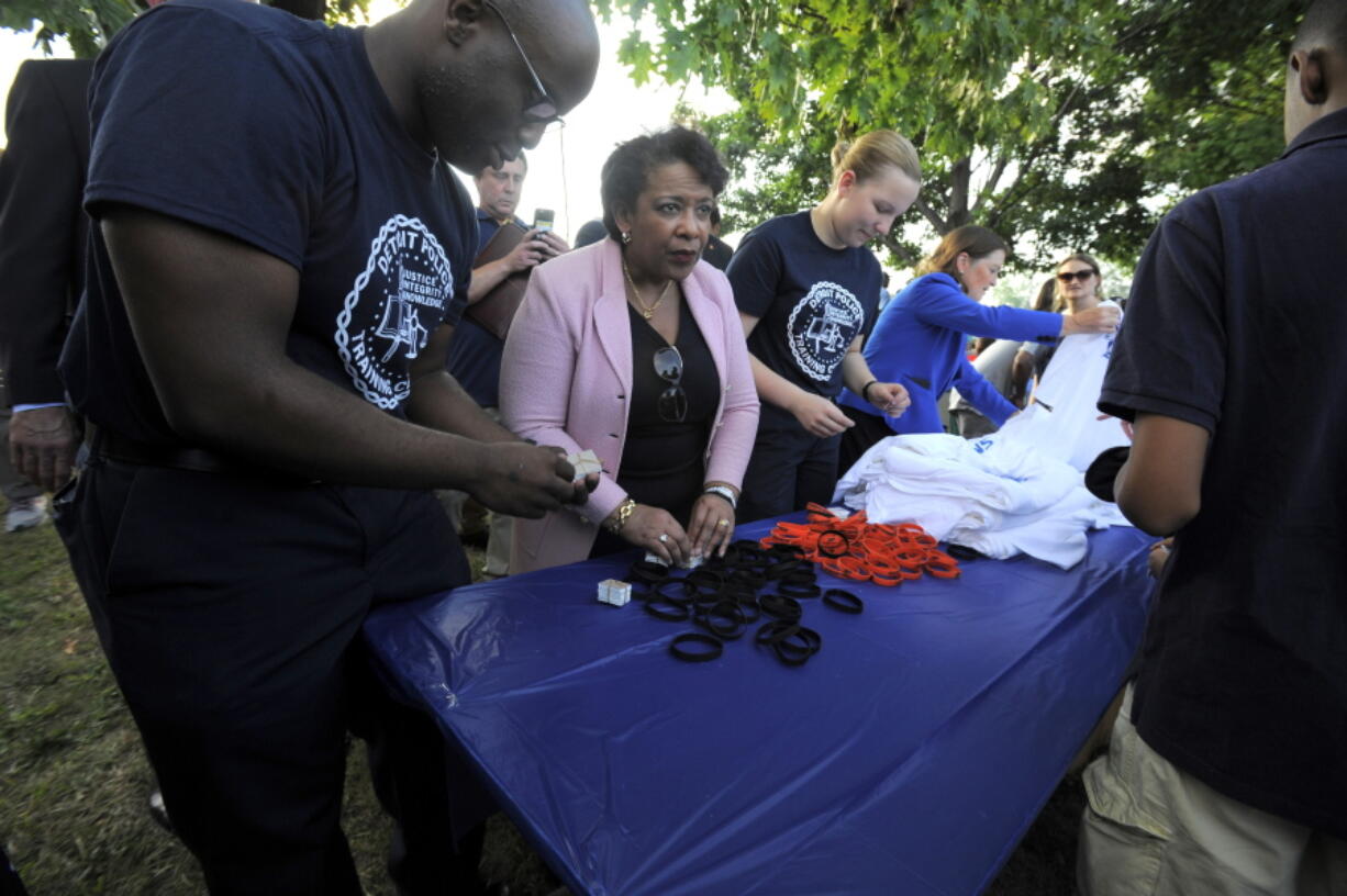 Attorney General Loretta Lynch hands out wristbands Tuesday  during a National Night Out event at Fitzpatrick Play Field in Detroit.