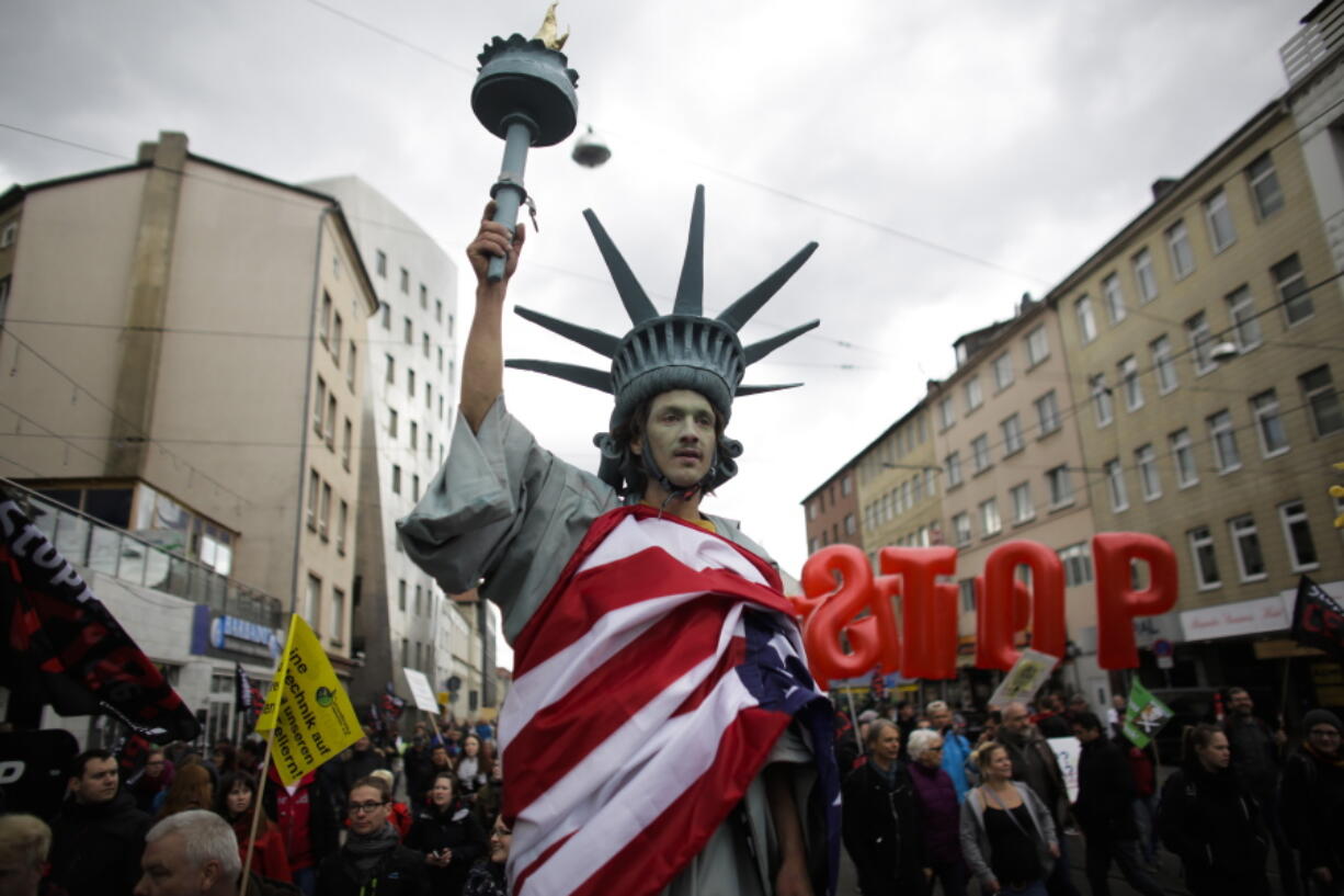 FILE - In this April 23, 2016 file picture a  man walking on stilts and dressed like the Statue of Liberty attends a protest  against the planned Transatlantic Trade and Investment Partnership, TTIP, ahead of the visit of United States President Barack Obama in Hannover, Germany. Germany???s economy minister Sigmar Gabriel  said Sunday Aug. 28, 2016  that free trade talks between the European Union and the United States have failed, citing lack of progress on any of the major chapters of the long-running negotiations.