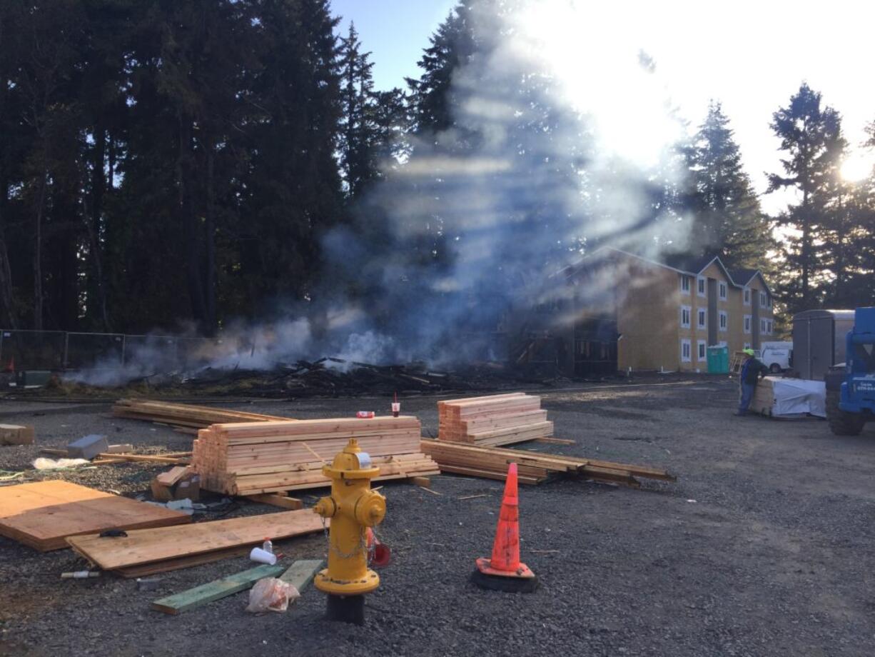 The remains of an apartment complex under construction off Northeast 66th Avenue smolder after a fire on the morning of Aug. 10.