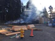 The remains of an apartment complex under construction off Northeast 66th Avenue smolder after a fire on the morning of Aug. 10.