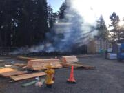 The remains of an apartment complex under construction off Northeast 66th Avenue smolder after a Wednesday morning fire.