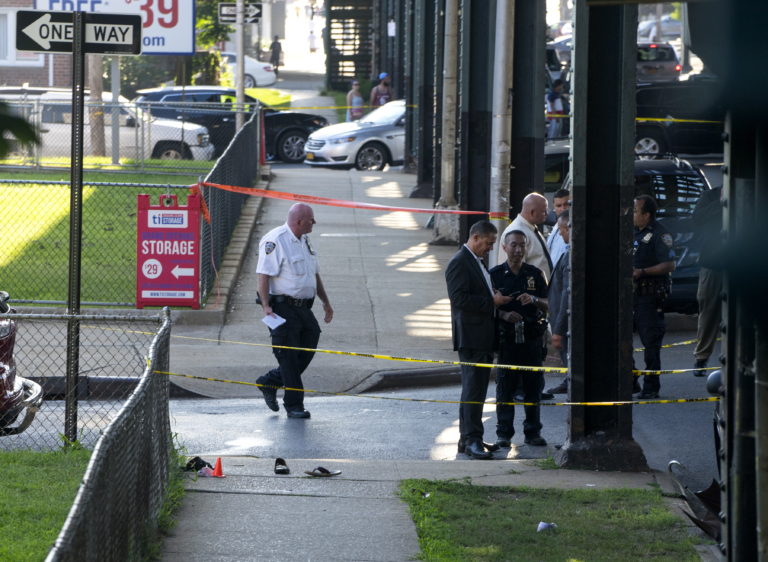 Sandals mark the crime scene, Saturday, Aug. 13, 2016, not far from the Al-Furqan Jame Masjid Mosque in the Ozone Park neighborhood of Queens, New York, where the leader of a New York City mosque has been fatally shot and an associate has been wounded in a brazen daylight attack.