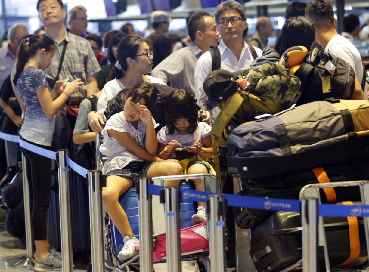 Passengers line up at check-in counter for Delta Air Lines at Narita international airport in Narita, east of Tokyo, on Tuesday.