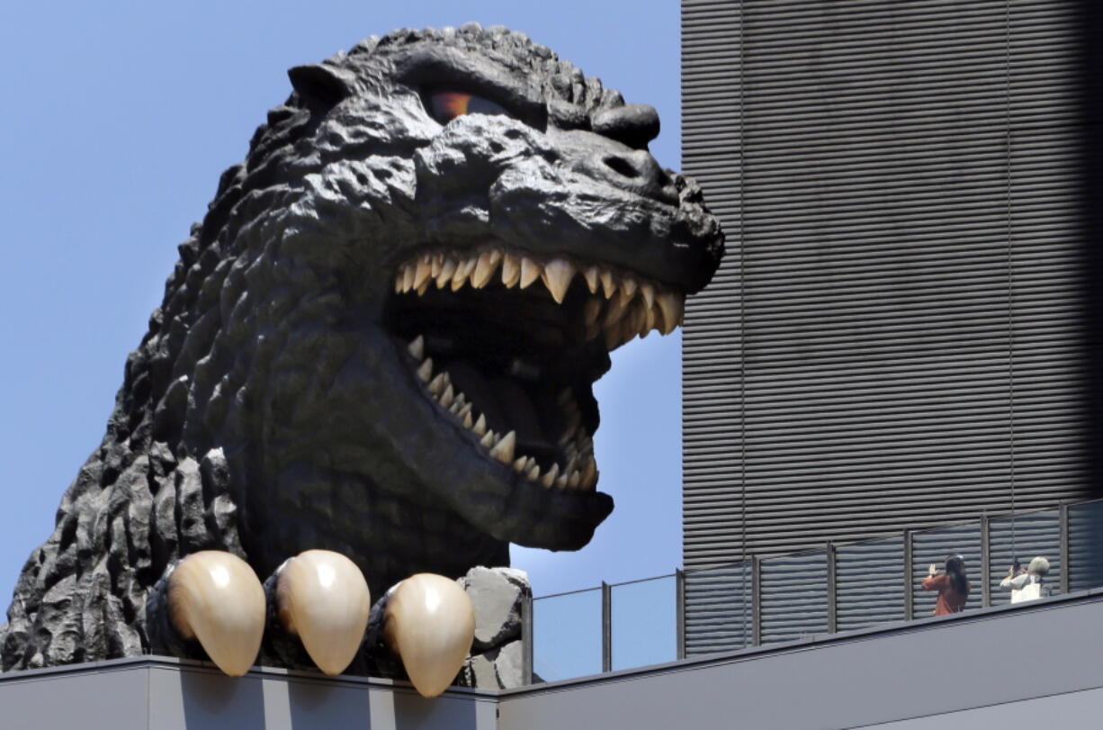 People take a picture of Godzilla&#039;s head at Shinjyuku Toho Building at Kabukicho district July 30 in Tokyo. The latest in the giant reptile Godzilla movies &quot;Shin Godzilla&quot; was released July 29 throughout Japan.