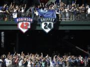 Taryn Griffey, center above number 24, the daughter of Seattle Mariners Hall-of-Famer Ken Griffey Jr., helps unveil Griffey's retired number 24 during a ceremony, Saturday, Aug. 6, 2016, at Safeco Field in Seattle. The number will be displayed next to Jackie Robinson's number 42 at Safeco Field. (AP Photo/Ted S.